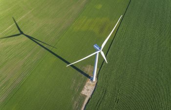 Wind turbine and countryside corn field, agriculture industry. Top aerial view